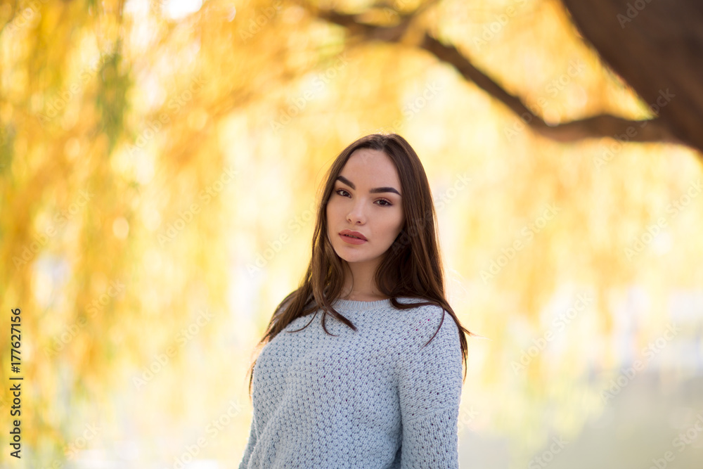 Portrait of brunette model with red lips posing in park on yellow background in autumn face close up, young fresh white pale skin. Portrait of brunette model with red lips posing in park on yellow background in autumn face close up, young fresh white pale skin.