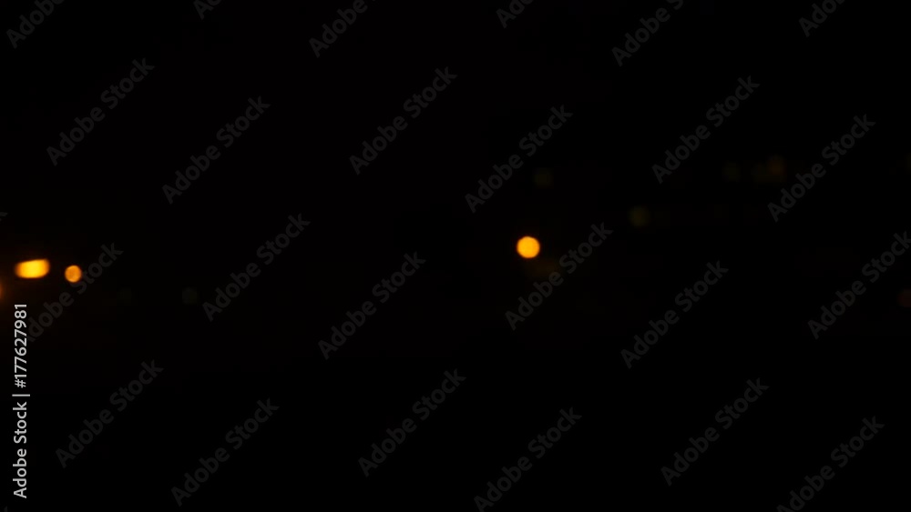 Night train view, bokeh balls from passing traffic and street lights.
