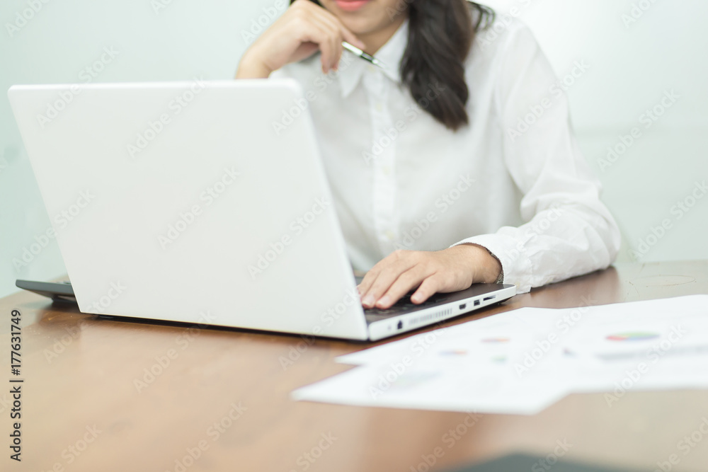 Young business woman working on laptop in office. Young business woman working on laptop in office.