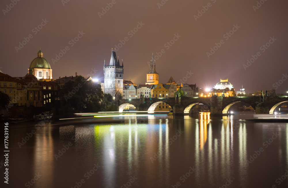 Charles Bridge and the Mill peninsula in Prague. Czech Republic. Light trails from boats walking along the river