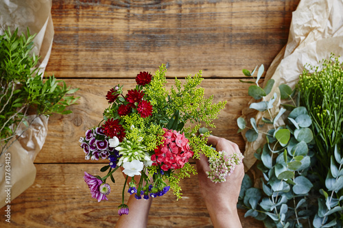 Canvas-taulu hands binding a wild flower bouquet flowershop