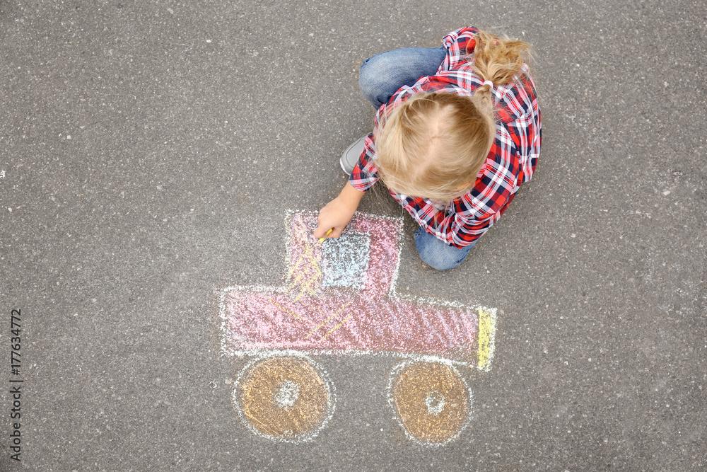 Fototapeta premium Little girl drawing car with chalk on asphalt