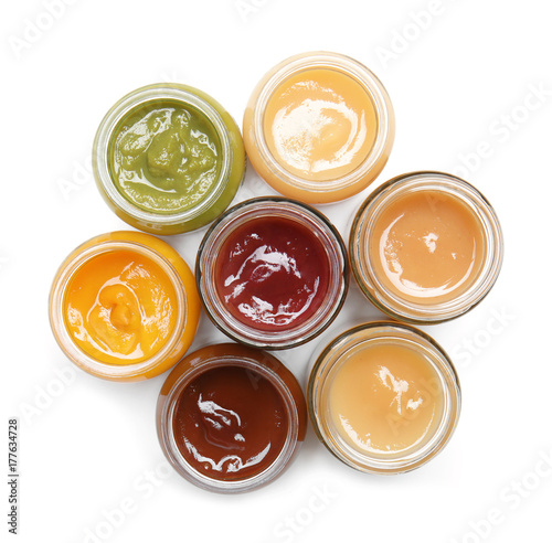 Jars with different baby food on white background