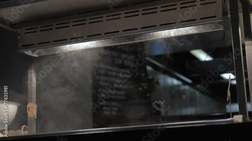 Slow motion shot of steam rising from the servery with just cooked hot dishes in self-service cafe photo