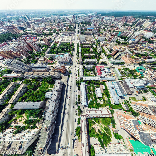 Aerial city view with crossroads and roads, houses, buildings, parks and parking lots, bridges. Helicopter drone shot. Wide Panoramic image.