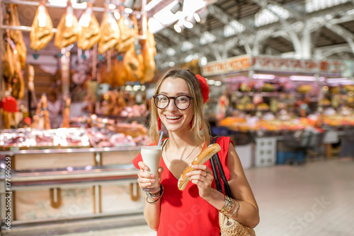 Woman portrait with Horchata, traditional spanish drink made from almonds, standing in the Central foodmarket of Valencia city photo
