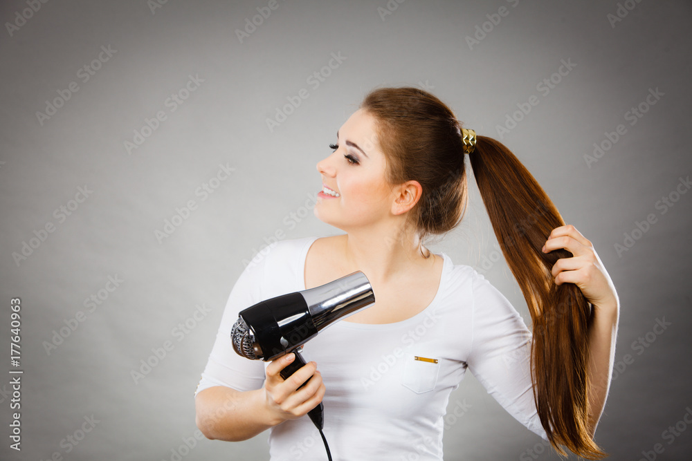 Woman drying her hair using hair dryer Woman drying her hair using hair dryer