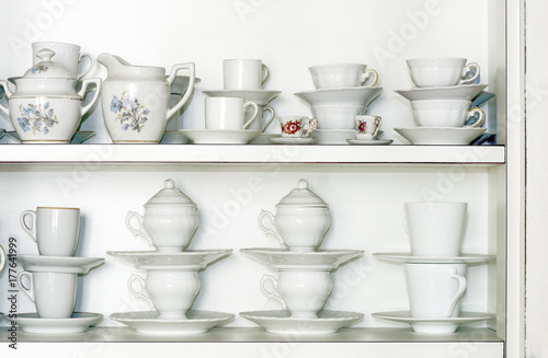 White kitchen cabinet shelf with decorated tea cups