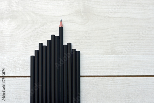 Set of building-shaped pencils on textured wooden plank