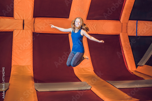 Foto Young woman sportsman jumping on a trampoline in fitness park and doing exersice