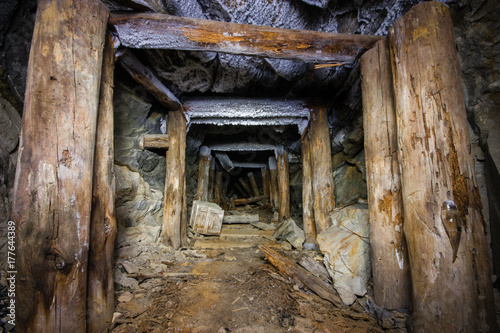 Old abandoned underground mica ore mine shaft tunnel with wooden stands