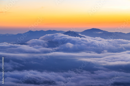 Clouds rolling over the mountains tops at sunrise © pwollinga
