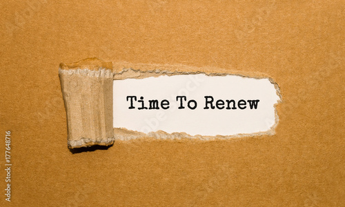 фотографія The text Time to renew appearing behind torn brown paper