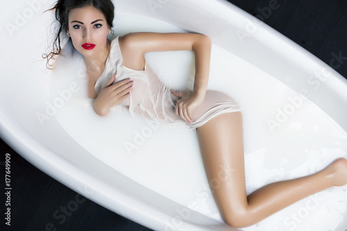 Beautiful young Woman relaxing in milk bath. Rejuvenation, skin pampering, treatment.