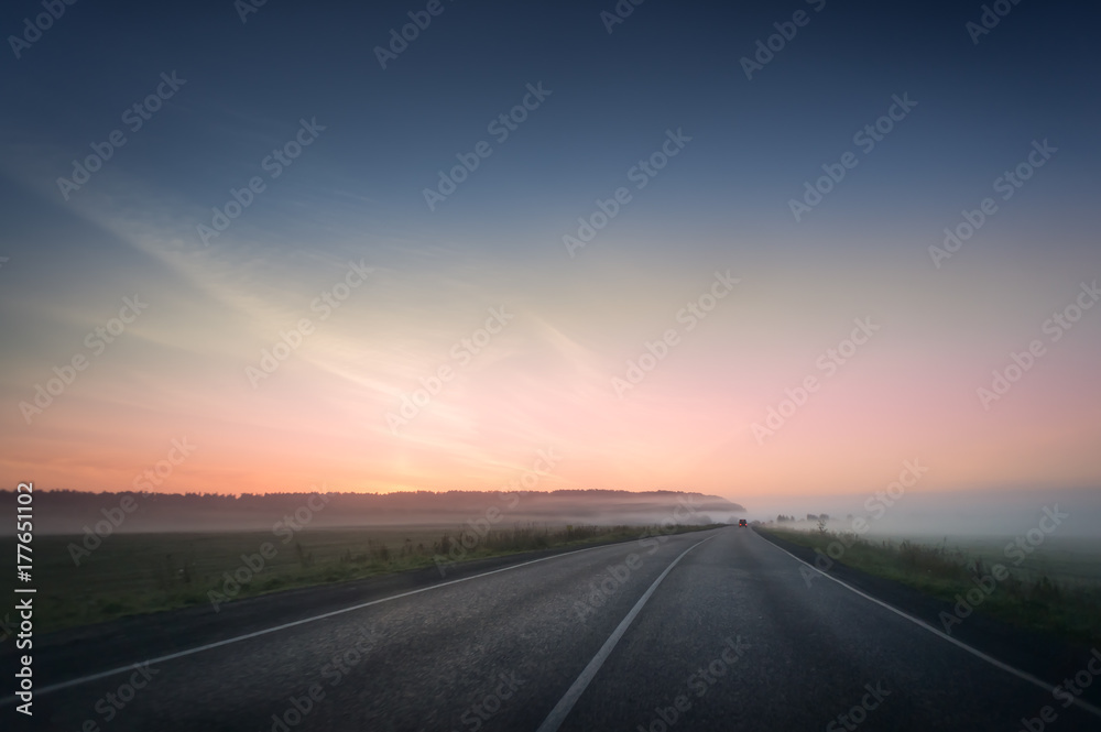 summer rural landscape with blue and red sky, fog and the road. sunrise