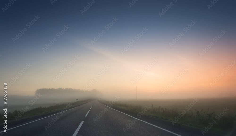 summer rural landscape with blue and red sky, fog and the road. sunrise