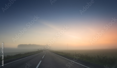 summer rural landscape with blue and red sky, fog and the road. sunrise © Mak