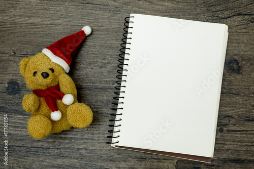 Christmas bear and white book with top view and copy space on the brown wooden table. Christmas festival concept. © Joeahead