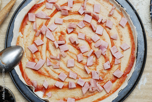 raw pizza dough with tomato sauce photo