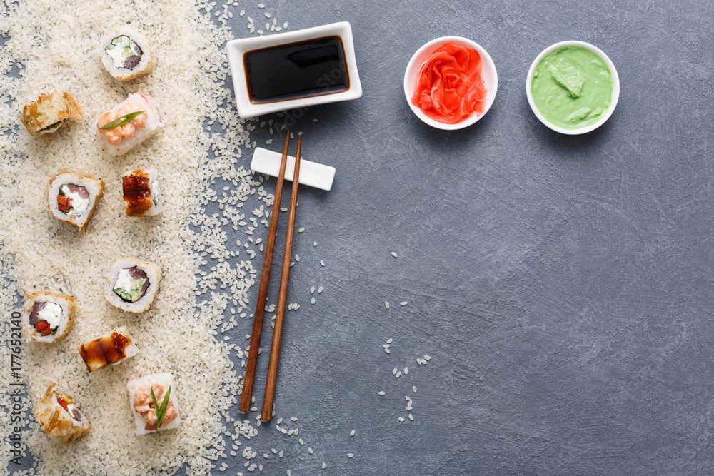 Top view on set of sushi roll, maki on rustic grey and white rice background Top view on set of sushi roll, maki on rustic grey and white rice background