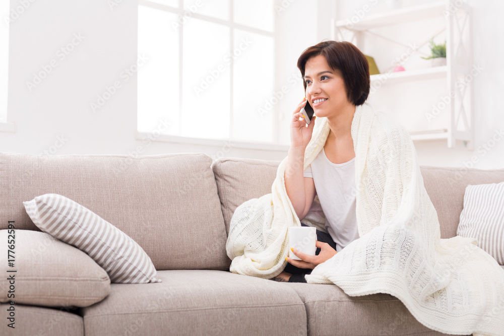 Cozy home. Girl in a blanket with mobile Cozy home. Girl in a blanket with mobile