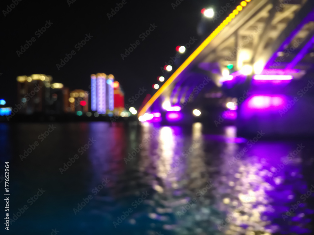 blurred bokeh lights of a city with buildings and bridge