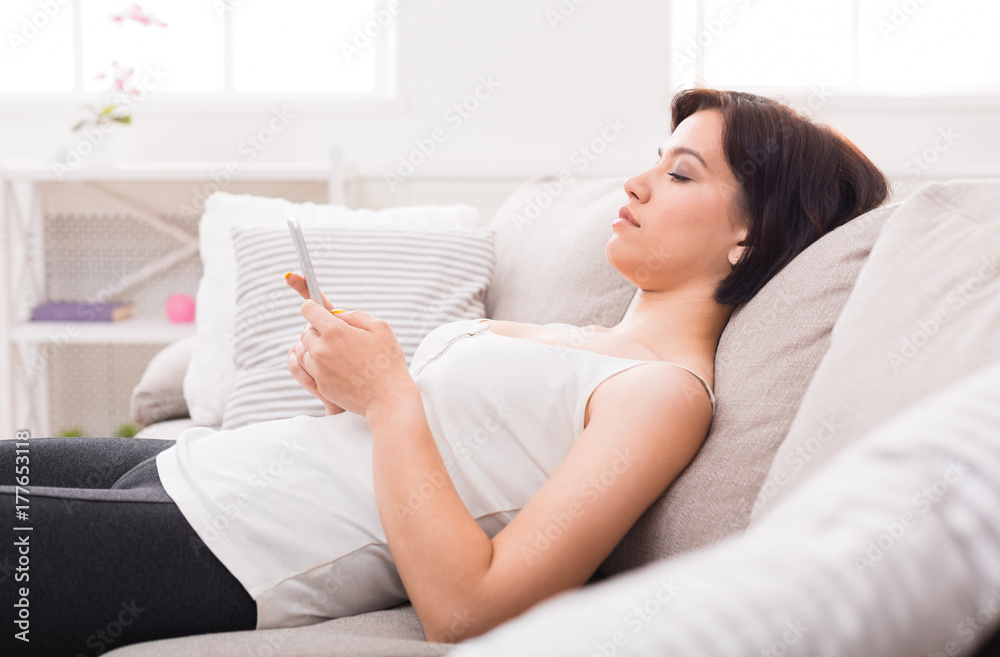 Young woman using a mobile phone on sofa. Young woman using a mobile phone on sofa.