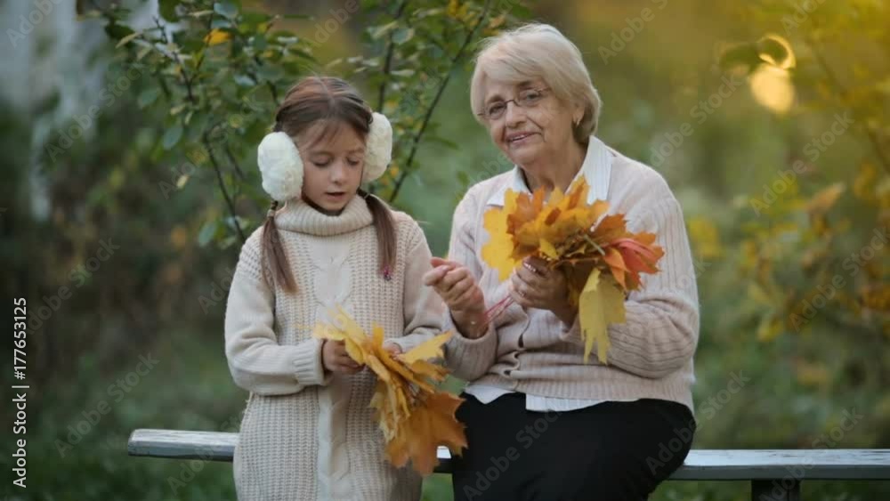 Grandmother with granddaughter in autumn garden