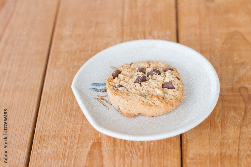 Chocolate chip cookie on a plate on a wooden table