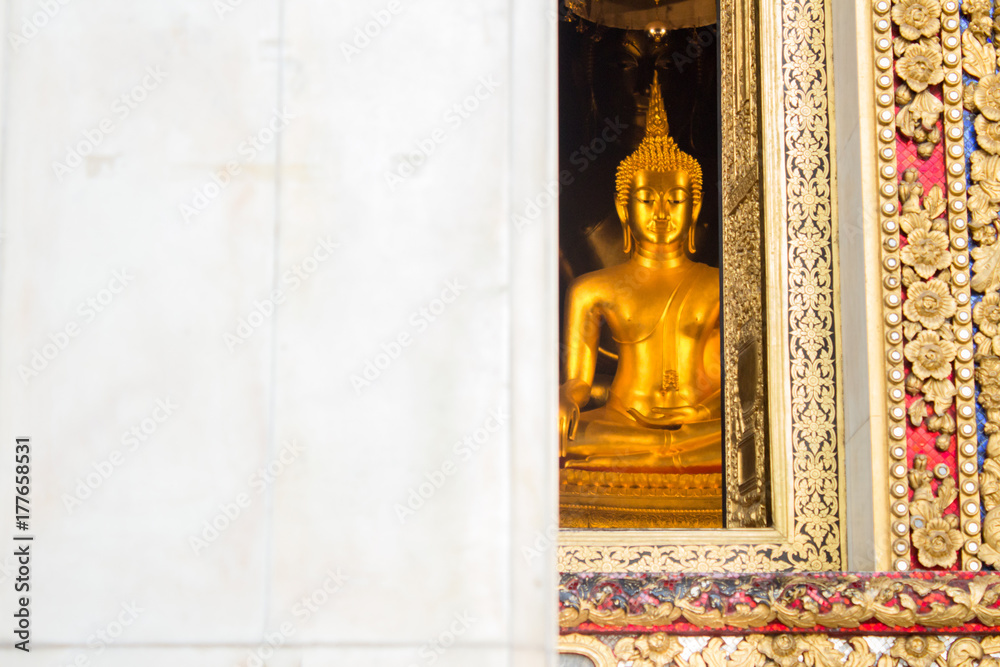 The main Buddha statue looking through the window of Wat Bowonniwet Vihara temple, Bangkok, Thailand