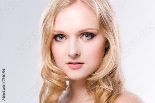 Portrait einer hübschen jungen blonden Frau vor weissem Hintergrund