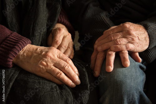Hands of an old woman and an old man sitting together