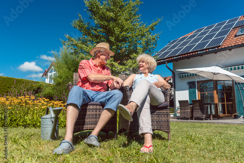 Glückliche Frau und Mann, ein Senioren Paar, entspannt im Garten vor dem Haus