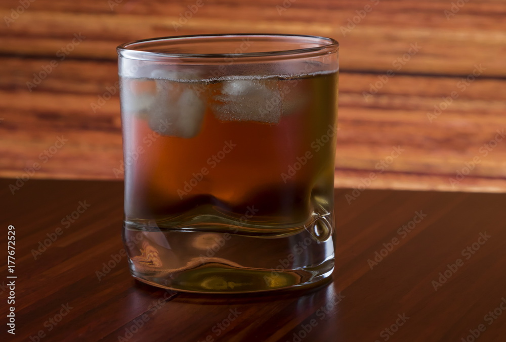 Glass of wiskey and ice on wooden background Glass of wiskey and ice on wooden background
