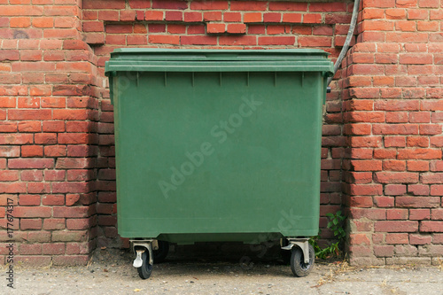  city green garbage container rubbish bin dustbins outside against brick wall background with copy space