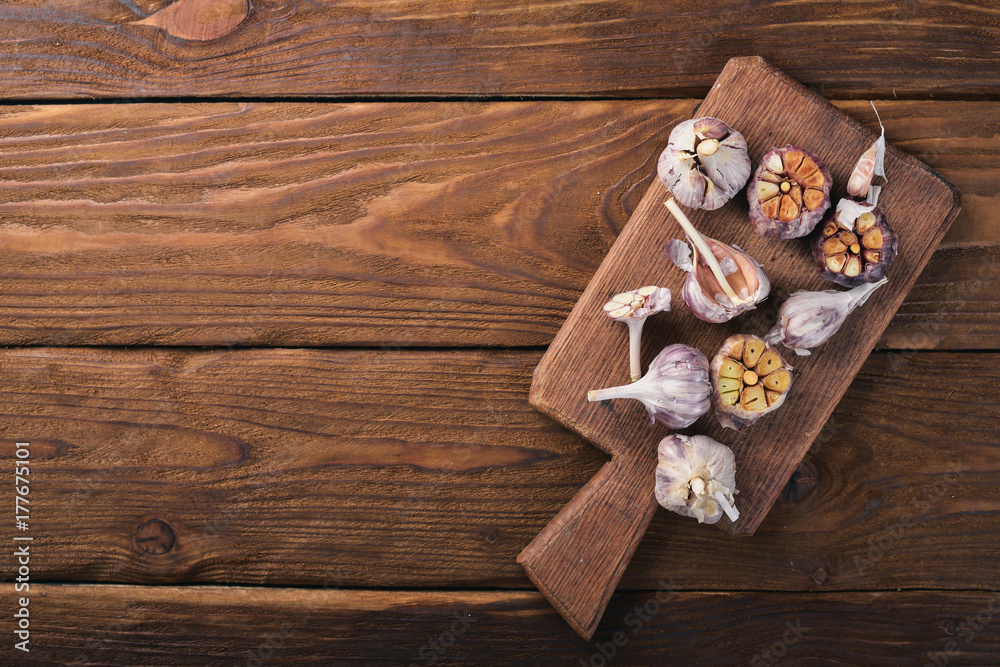 Garlic. On a wooden background. Top view. Free space for your text.