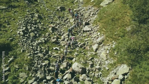 Aerial view tourist group walking on mountain trail. Climbling a mountain photo