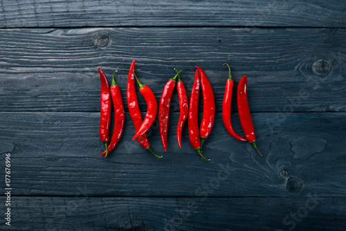 Chili red pepper. On a wooden background. Top view. Free space for your text.