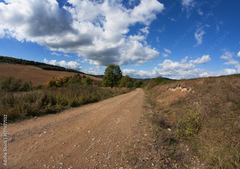 gravel road leading to the hills and the blue sky