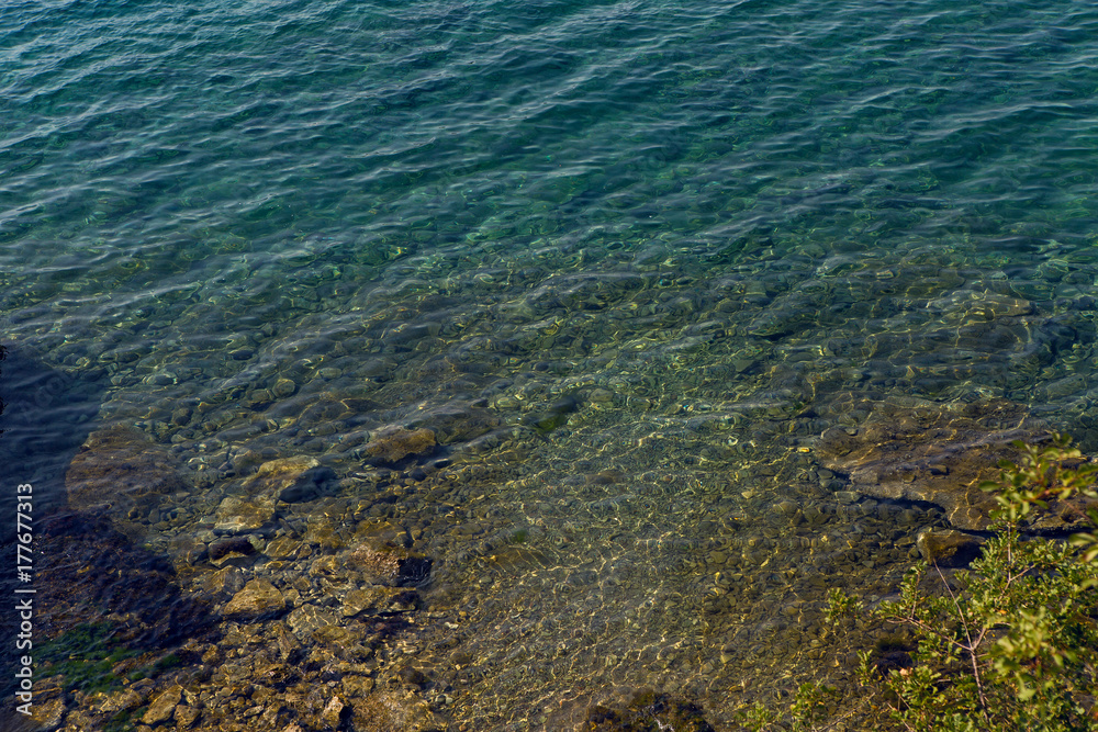 sea with a stone bottom and a blue clear water