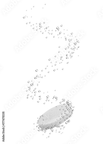 Medical pill dissolves in water with bubbles close-up, isolated on white background