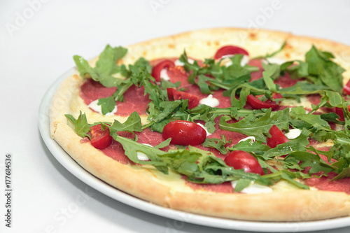 Pizza with prosciutto (parma ham), arugula (salad rocket) and parmesan isolated on white background. Italian cuisine photo