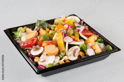 Salad in takeaway container on white background