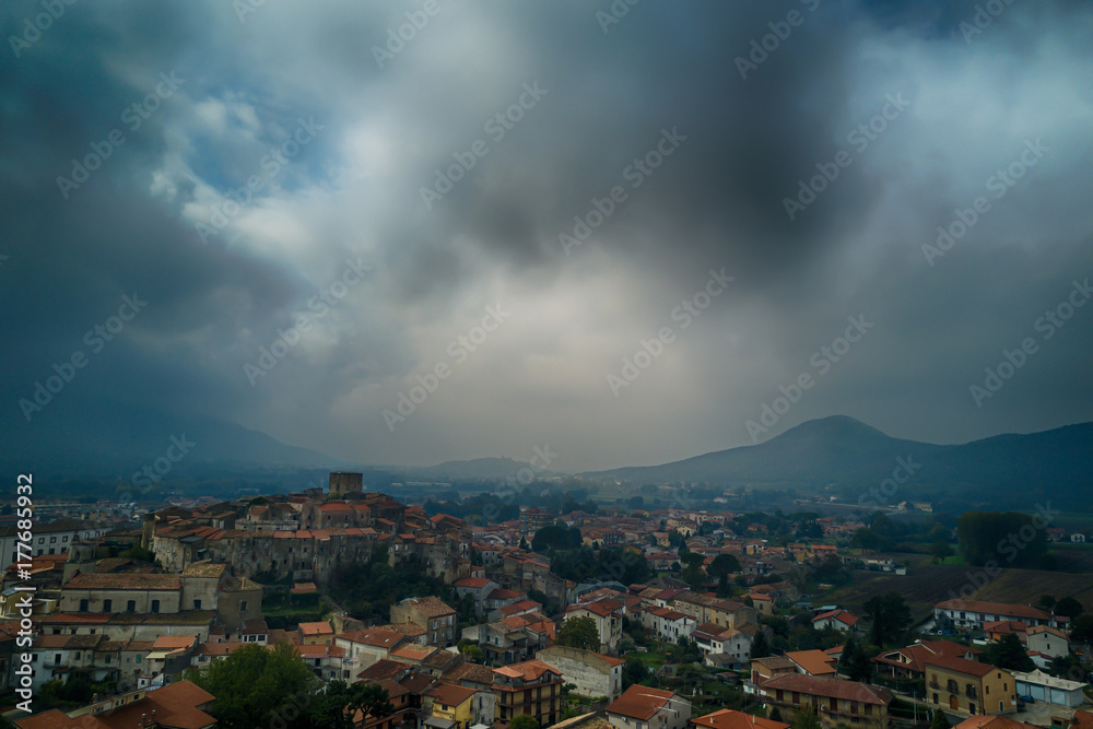 Medieval italian old village aerial view with clouds and mountains