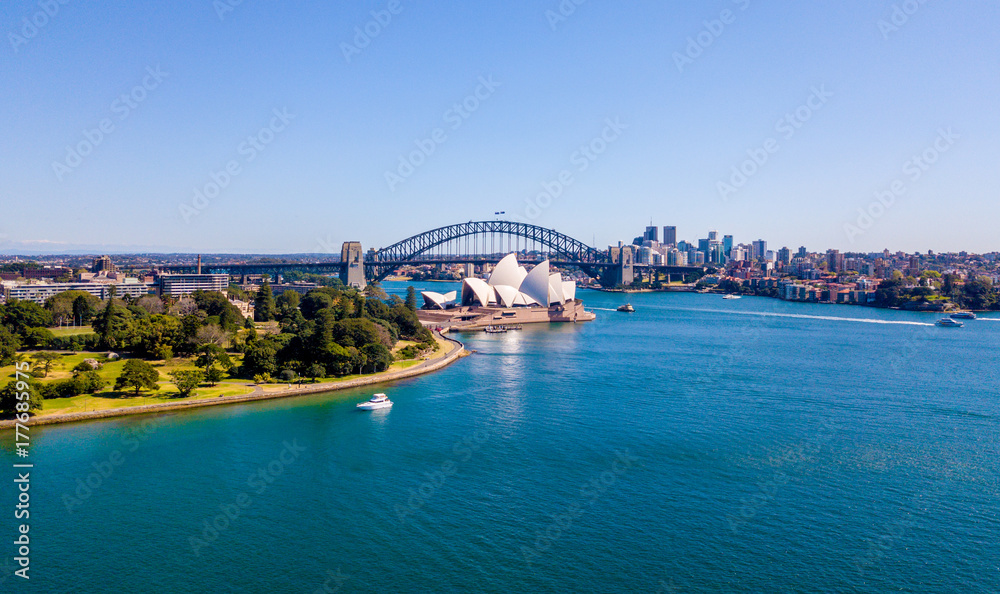 Naklejka premium Piękna panorama dzielnicy portowej w Sydney z mostem Harbour Bridge, ogrodem botanicznym i budynkiem Opery.
