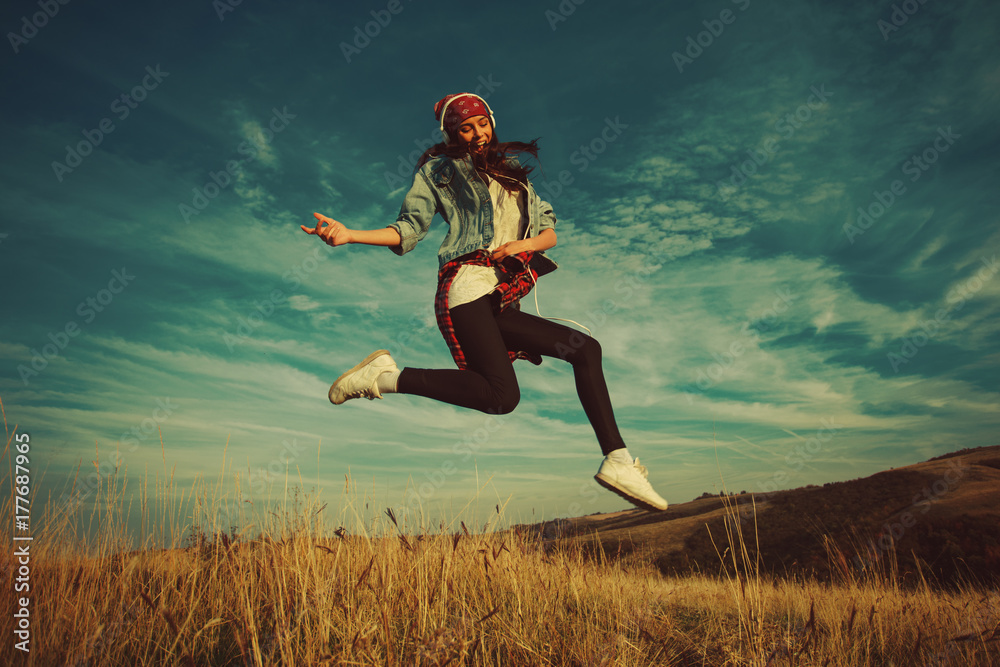 Happy young woman jump in the air in nature