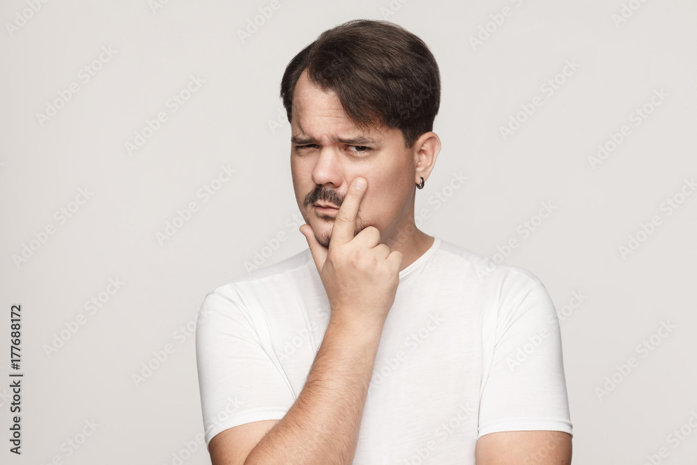 Suspicion, distrust concept. Man looking at camera and touching chin Suspicion, distrust concept. Man looking at camera and touching chin