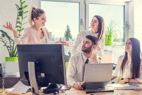 Young businesswoman bragging to her colleagues in office.
