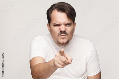 Anger adult man pointing finger at camera.