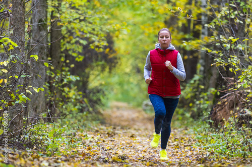 Fototapeta Naklejka Na Ścianę i Meble -  Woman running in the autumn park